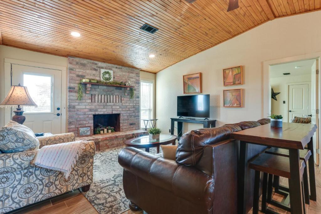 a living room with a leather couch and a fireplace at Ranch Getaway with Pool and Horse Stall Access! in Calera