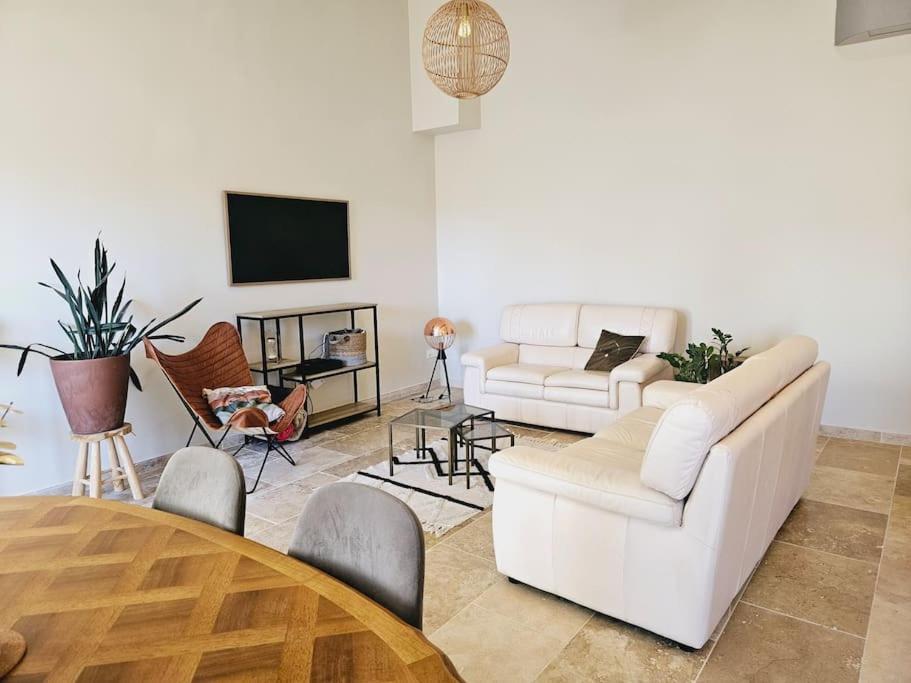 ein Wohnzimmer mit 2 weißen Sofas und einem Tisch in der Unterkunft Le gîte de la marquise - Elégant appartement avec terrasse - in Montboucher-sur-Jabron