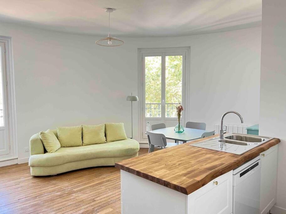 a kitchen and living room with a couch and a table at Magnifique appartement familiale 6 personnes 3 chambres et 3 salles de bain en hyper centre avec rue piétonne Parking 20m in Troyes