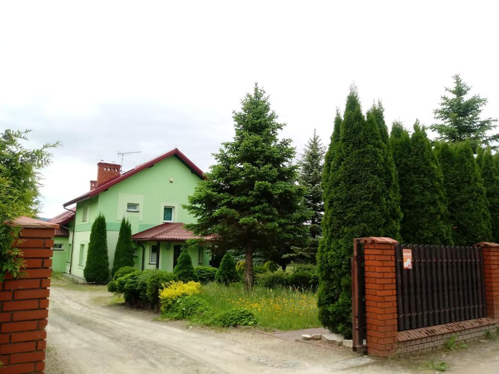 a house with a fence in front of a road at Apartament Tadeusz 2 B in Krynica Zdrój