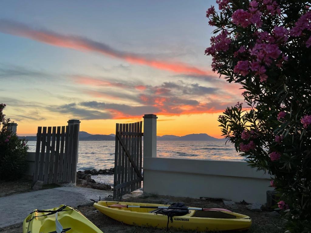 a yellow kayak sitting on the beach with a sunset at Dimitra Houses 2 - Seaside in Lefkimmi