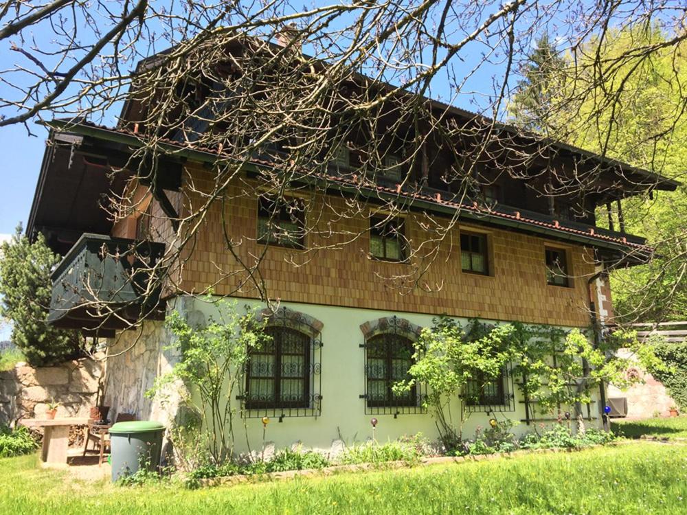 une maison ancienne avec de nombreuses fenêtres dans une cour dans l'établissement Waldhofalm Angerer, à Berchtesgaden