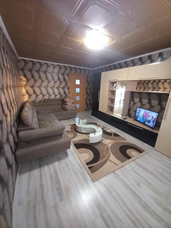 uma sala de estar com um sofá e uma televisão em Apartament cu 2 camere em Hunedoara