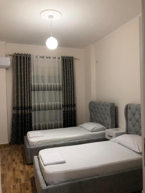 a room with two beds and a window at Drini Apartments in Përmet