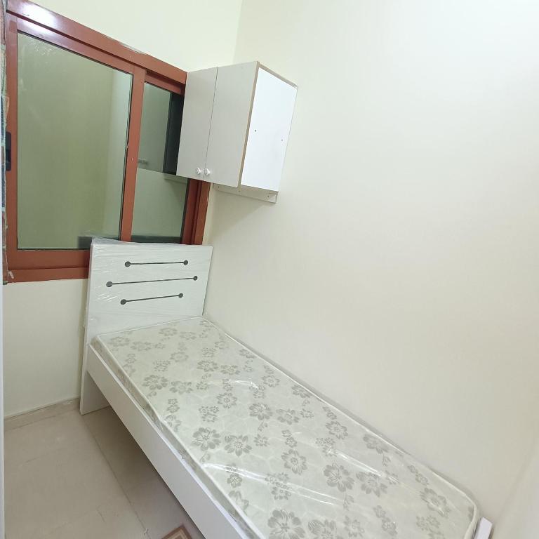 Al Basam Center في دبي: غرفة صغيرة بها سرير ومرآة