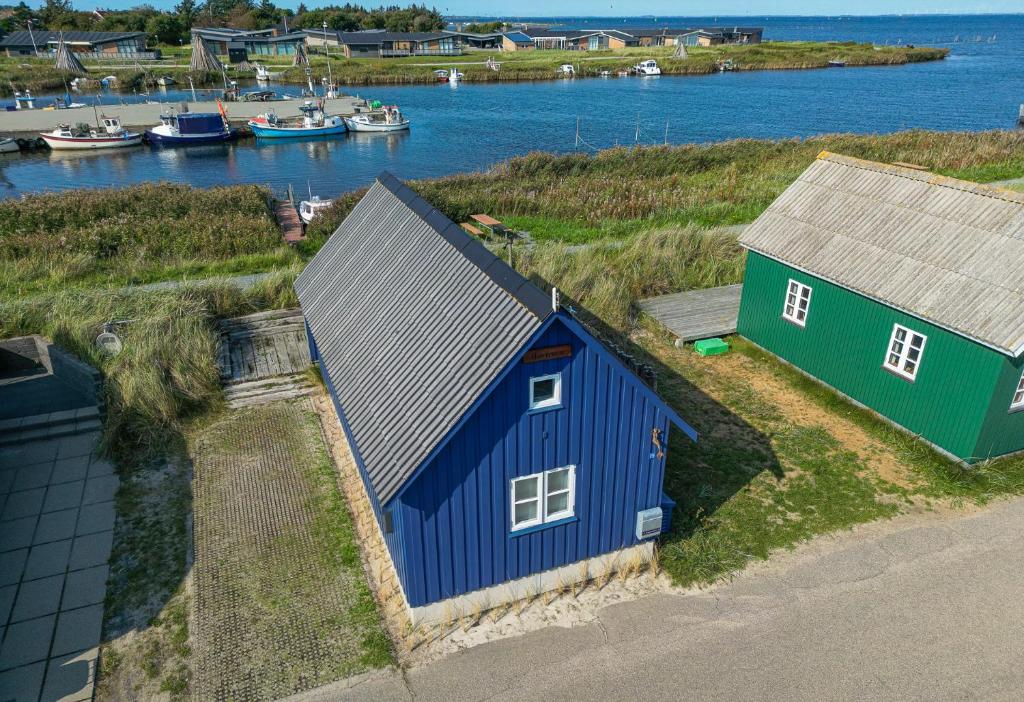 eine Luftansicht von zwei Häusern und einem Hafen mit Booten in der Unterkunft Harbour Living in Hvide Sande