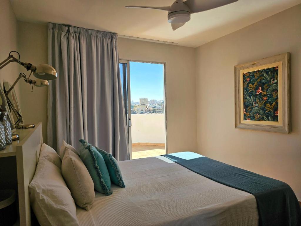 ラスパルマス・デ・グランカナリアにあるEl ático de Conchaのベッドルーム1室(ベッド1台、大きな窓付)