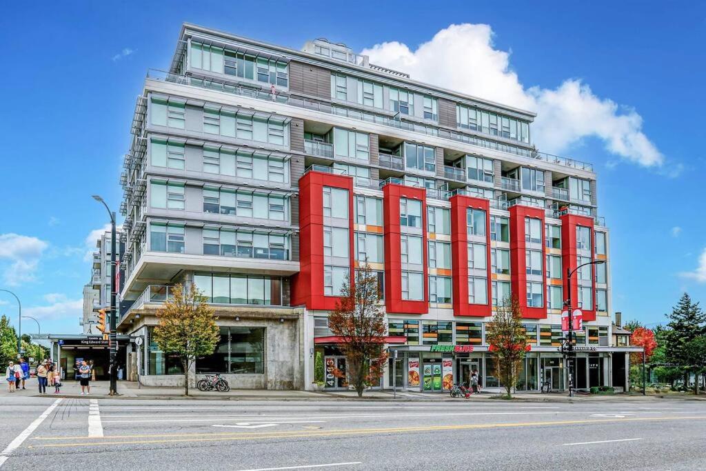 a red building on the corner of a street at Cambie&Elizabeth Park 2BDR/Parki in Vancouver