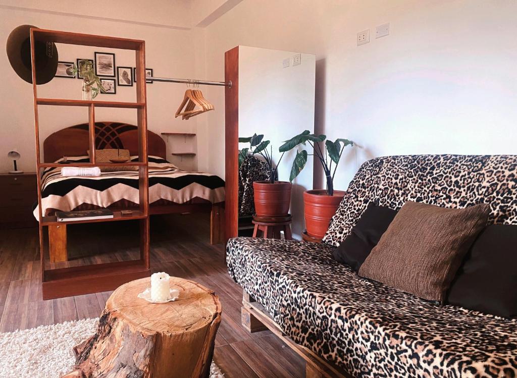 a living room with a bed and a table with a tree stump at La Casa de Damien in Urubamba