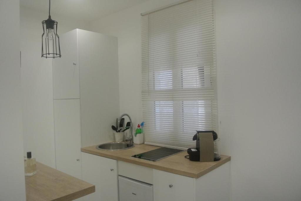 a kitchen with a sink and a window with blinds at Chabanon in Marseille