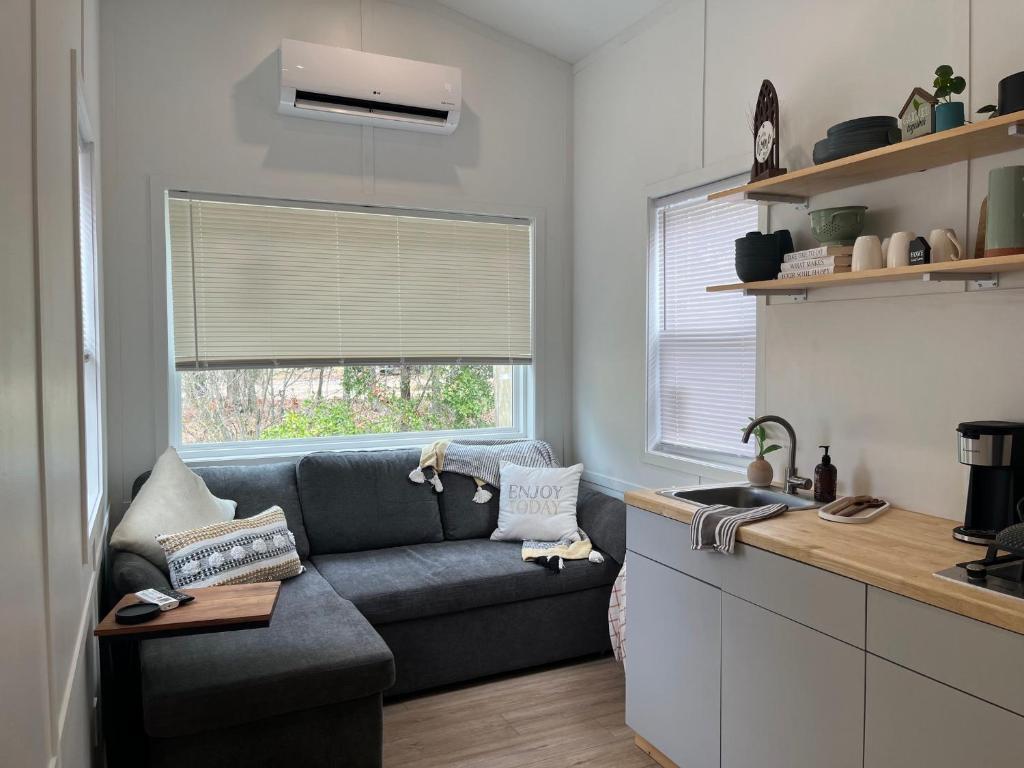 a living room with a couch and a window at The Abb Tiny Home in Perry