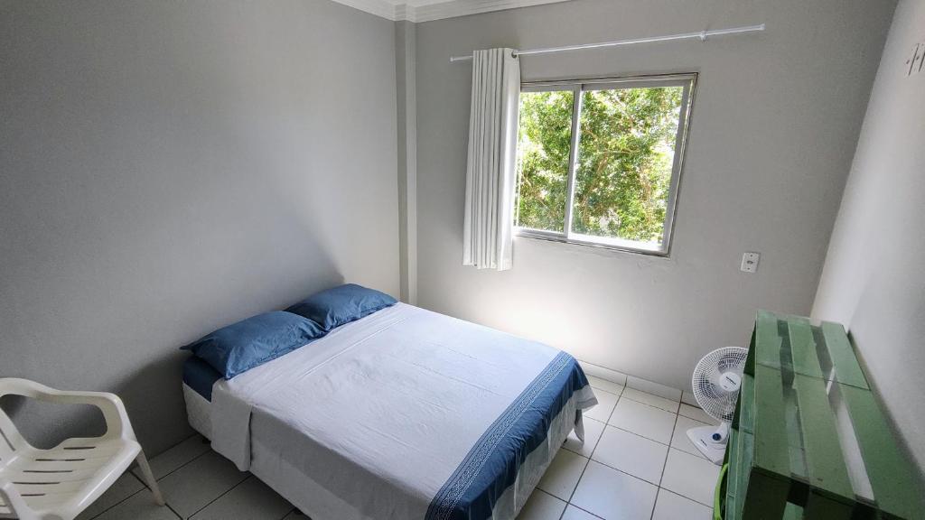 a small bedroom with a bed and a window at Ed Bertholi - Vista lateral do mar com garagem in Serra