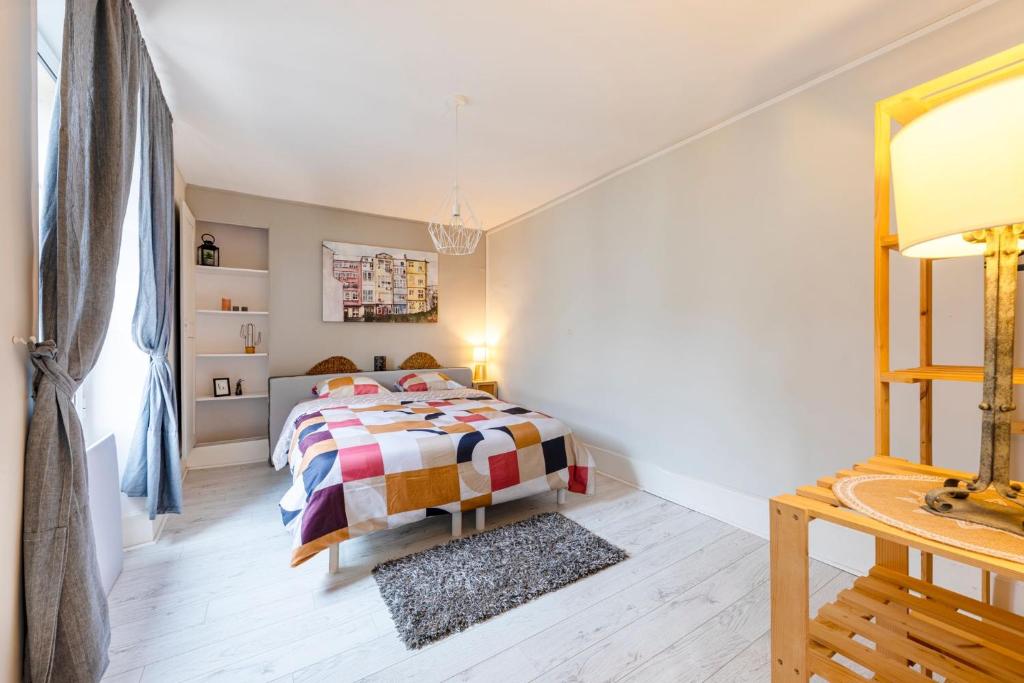 a bedroom with a bed and a table and a mirror at La Maison du Centre GOUVIEUX - CHANTILLY in Gouvieux