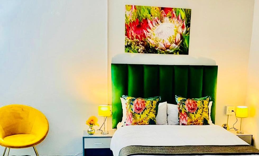 a bedroom with a bed with a green headboard at Pelican Corner in Durban