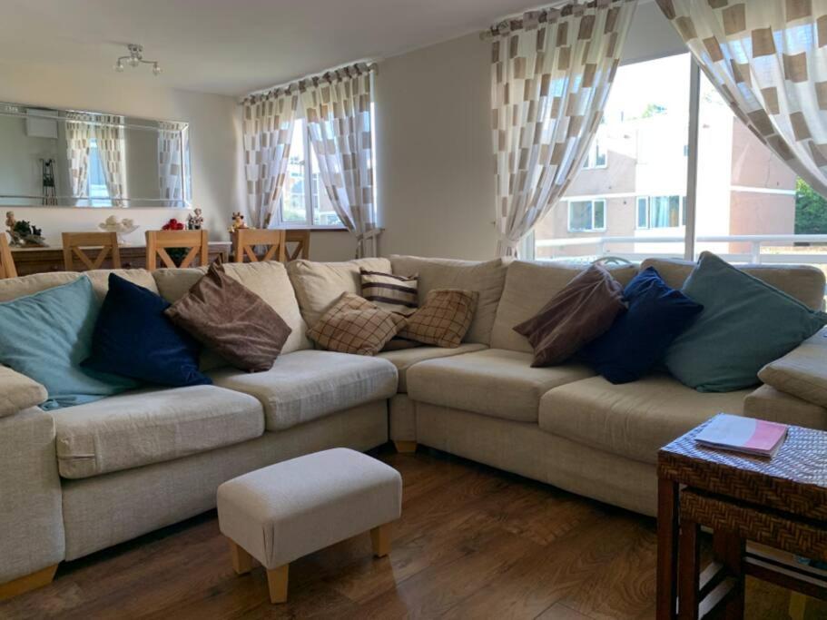 - un salon avec un canapé et des oreillers dans l'établissement Spacious 2 Bed Elstree Borehamwood Hertfordshire, à Elstree