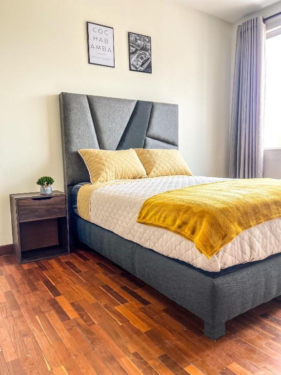 a bedroom with a bed with a yellow blanket at Hermoso Departamento completo en la mejor zona de Cochabamba in Cochabamba