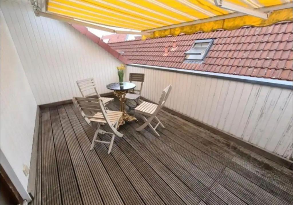 a patio with a table and chairs on a deck at Schwert Apartment Verden in Verden