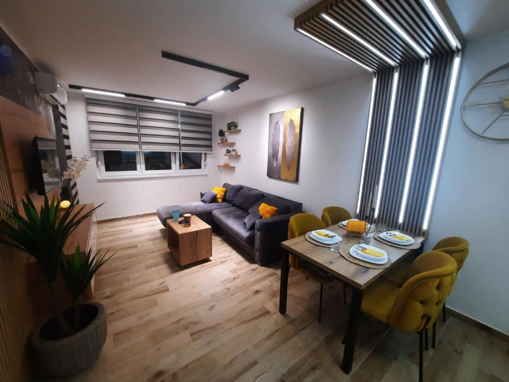 a living room with a blue couch and a table at Apartman Lux-besplatno korišćenje zasebne garaže in Sremska Mitrovica