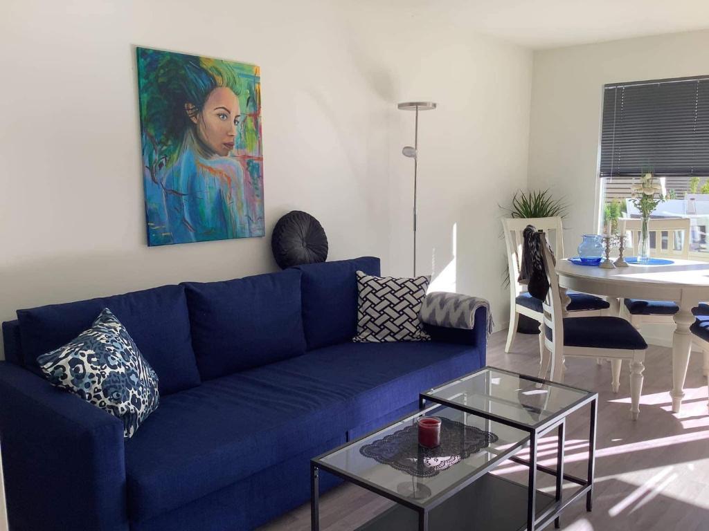 sala de estar con sofá azul y mesa en SylviaBo, en Skien