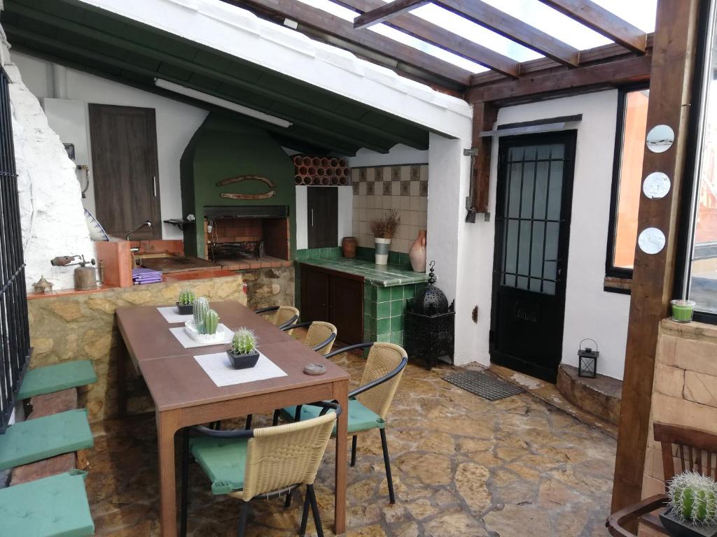 patio con mesa y sillas y cocina en La Vieja Escuela, en Fuentes de Rubielos