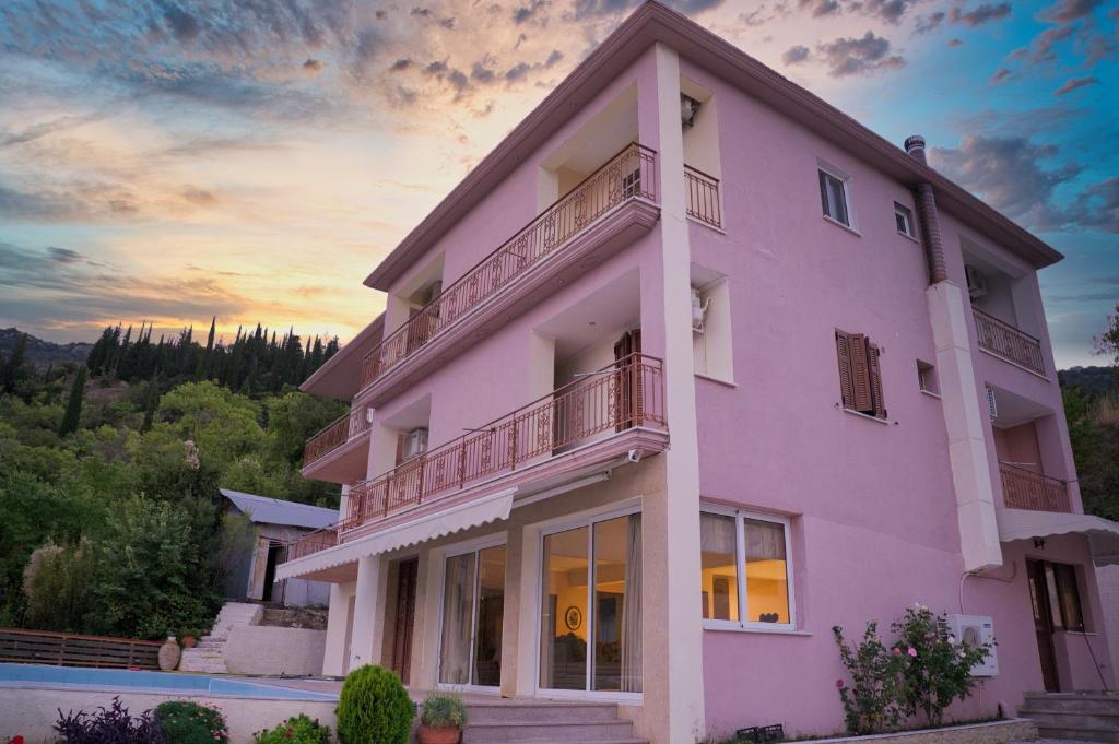 a pink building with a sunset in the background at Petronas Villa in Kariá
