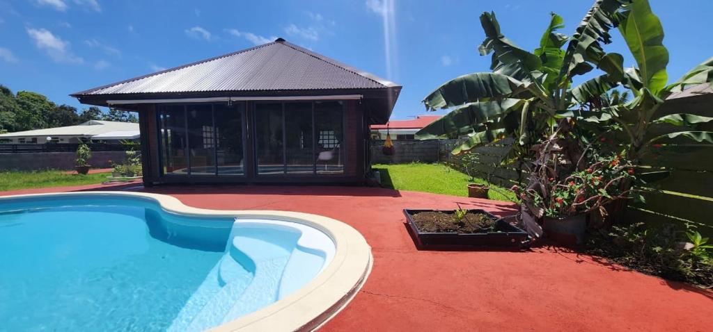 a swimming pool in a yard with a gazebo at Heipoe Lodge in Uturoa