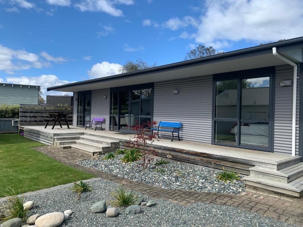 ein Haus mit großen Glasfenstern und einer Terrasse in der Unterkunft A Beauty on Bligh St Te Anau in Te Anau