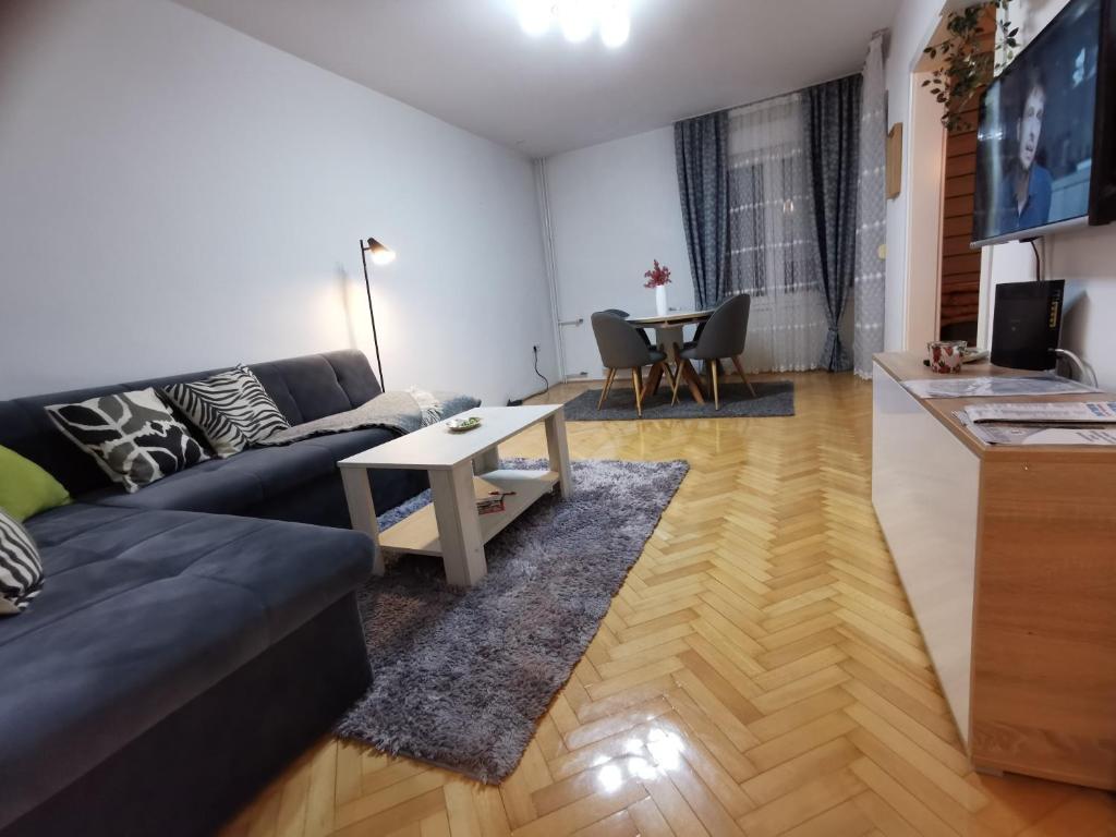 een woonkamer met een bank en een tafel bij Apartman Paradiso BN in Bijeljina
