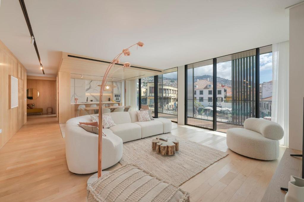 ein Wohnzimmer mit weißen Möbeln und großen Fenstern in der Unterkunft Luxury in the heart of the city - Savoy Insular I in Funchal