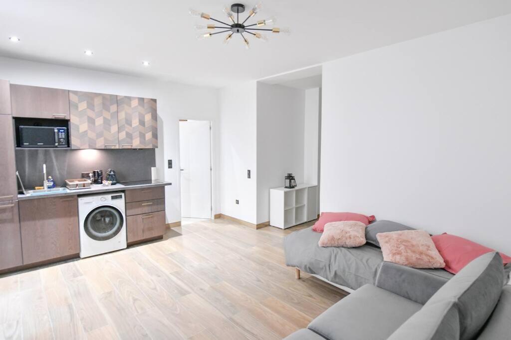 un salon avec un canapé et une cuisine dans l'établissement Suites Sacré-Cœur Basilica, à Paris