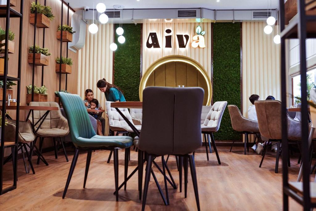 a restaurant with chairs and people sitting at tables at Aiva Hostel in Bishkek