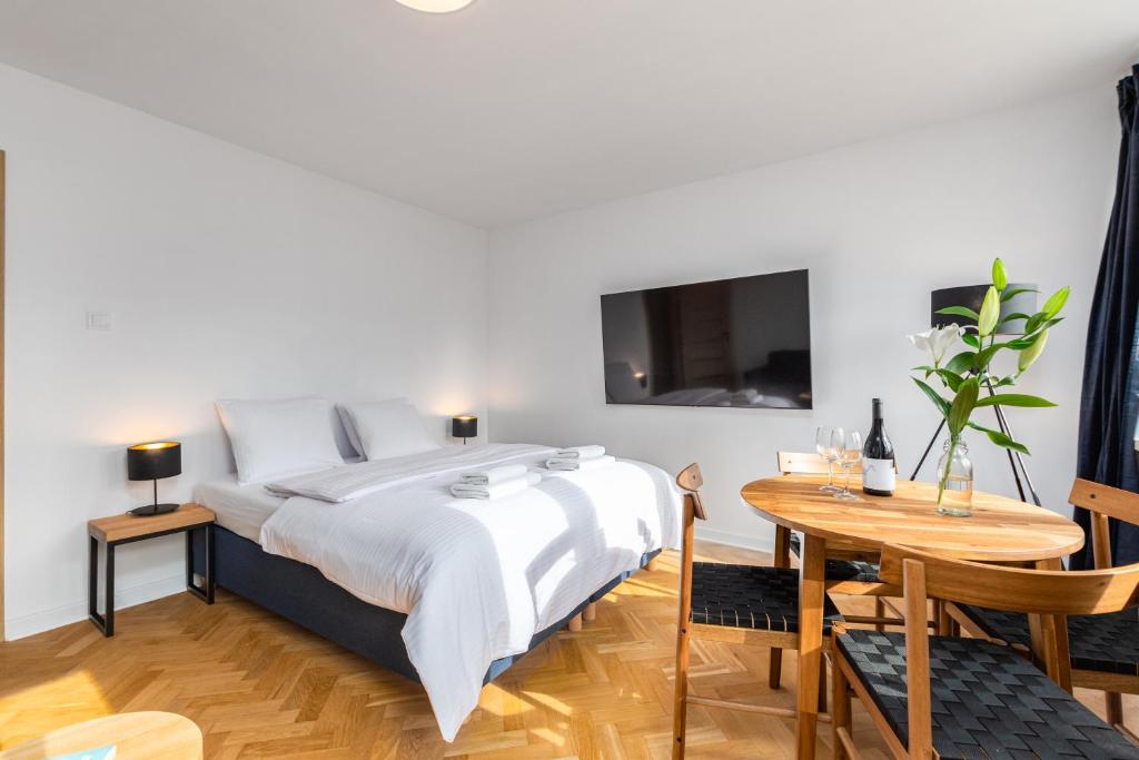 1 dormitorio con cama, mesa y TV en Apartament Jasna by Your Freedom, en Varsovia