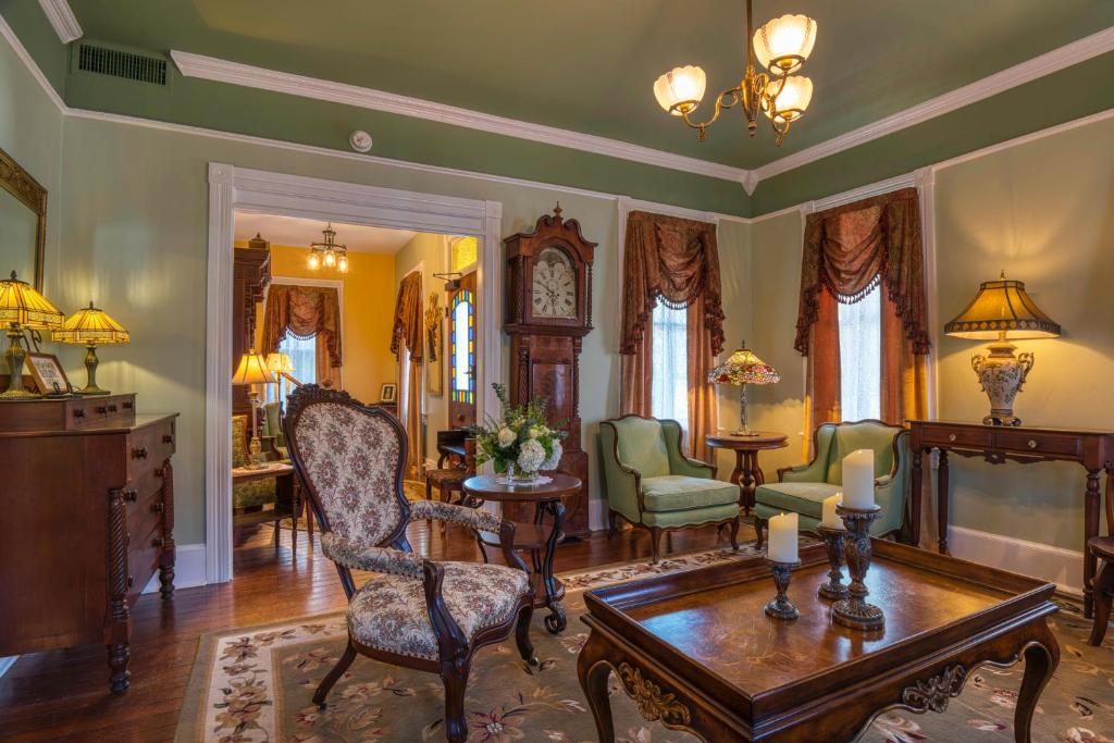 sala de estar con mesa, sillas y reloj en Victorian House Bed and Breakfast en St. Augustine