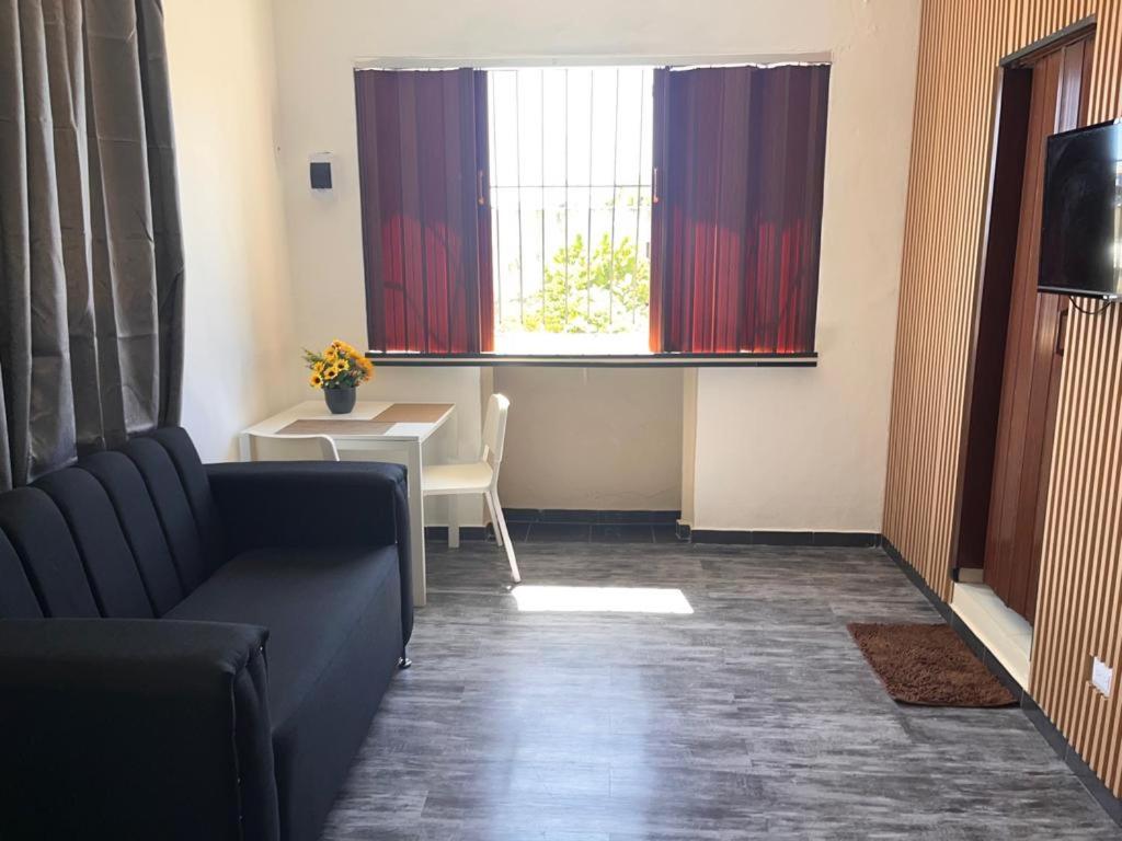 a living room with a couch and a table and a window at APARTAMENTO ZONA COLONIAL R in Santo Domingo
