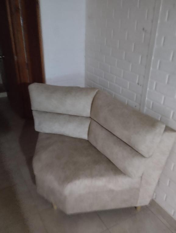 un sofá blanco sentado en una esquina de una habitación en Cabañas villa Luz, en Armenia