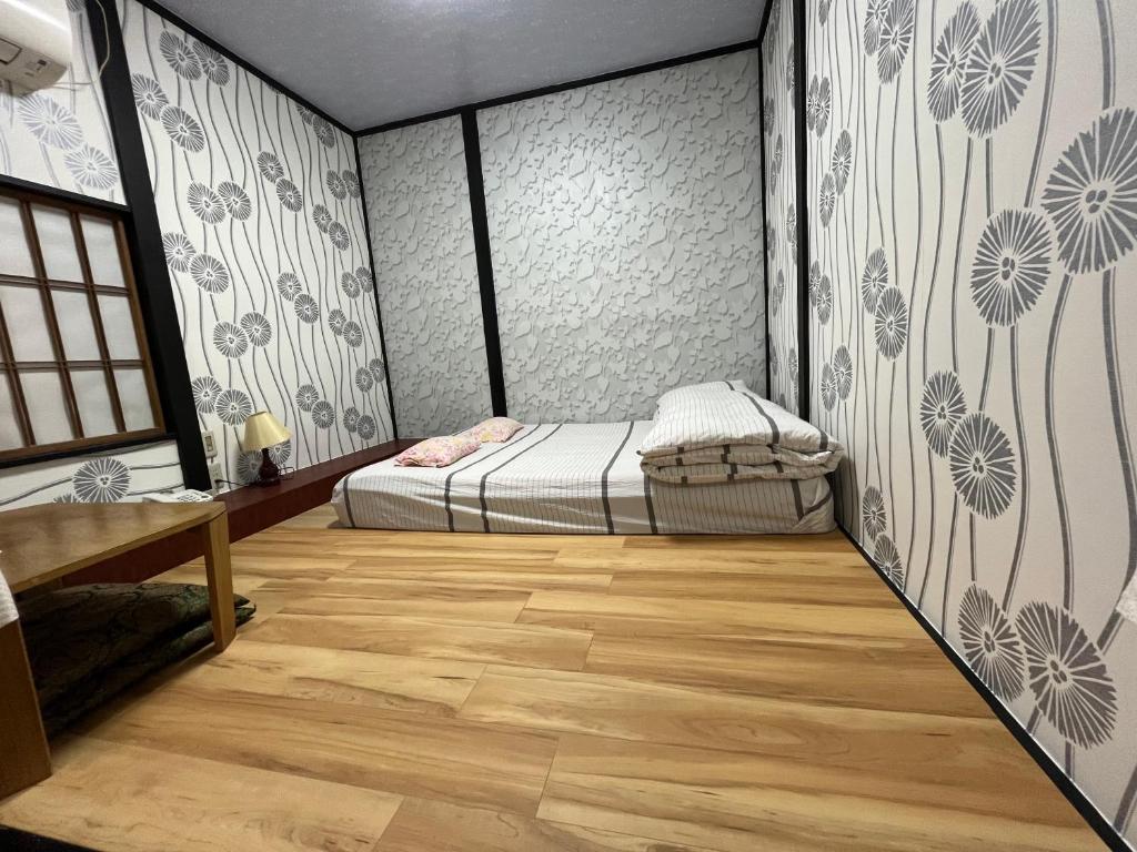 a bedroom with a bed and a wooden floor at Lucky Hotel in Tokyo