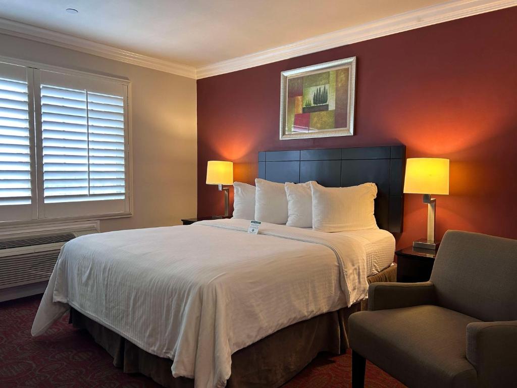 ロサンゼルスにあるベスト ウエスタン バーバンク エアポート インのベッドと椅子付きのホテルルーム
