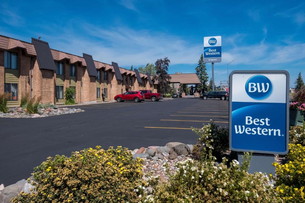 un cartel en frente de un edificio con un autobús mejor occidental en Best Western Bridgeview Hotel, en Superior