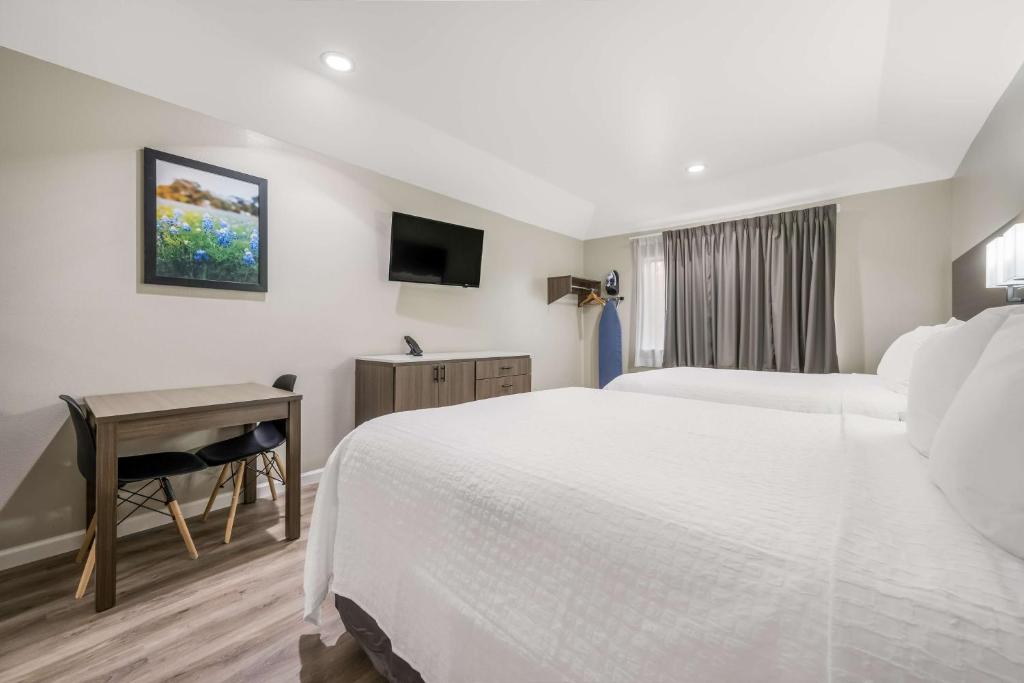 Postel nebo postele na pokoji v ubytování SureStay Studio by Best Western Conroe Downtown