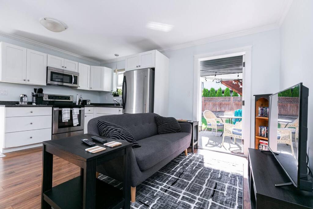 een woonkamer met een bank en een tafel bij Great 1-bedroom Suite Near Downtown Langford in Victoria