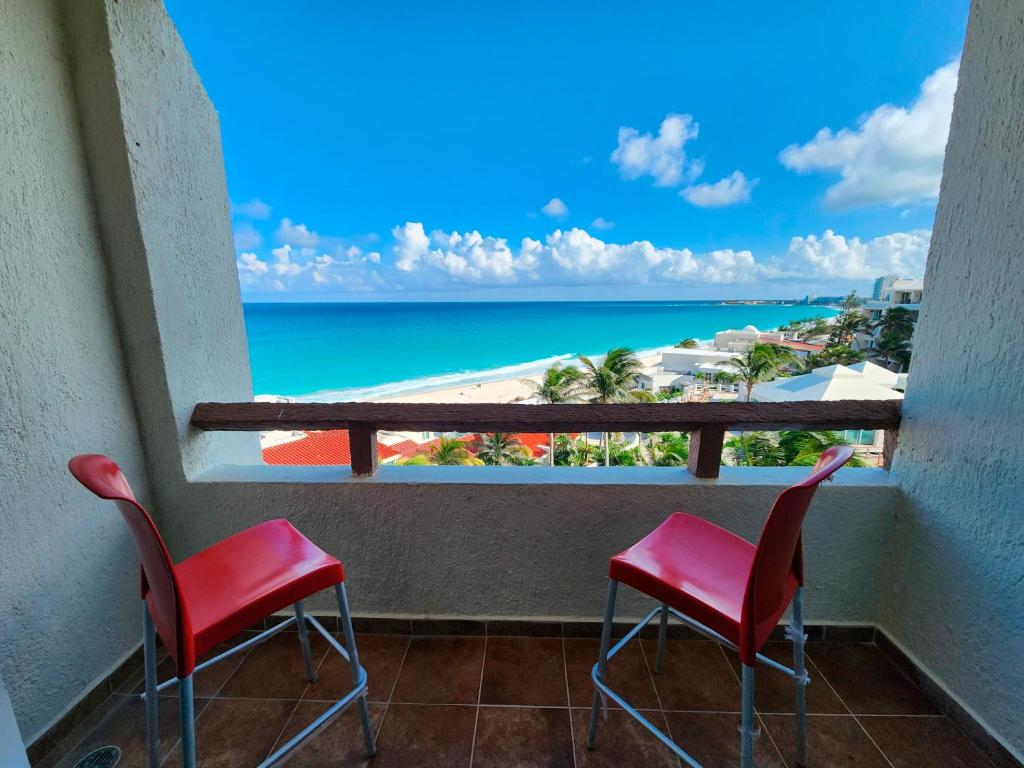 d'un balcon avec deux chaises et une vue sur la plage. dans l'établissement Beachfront apartments Cancun, à Cancún