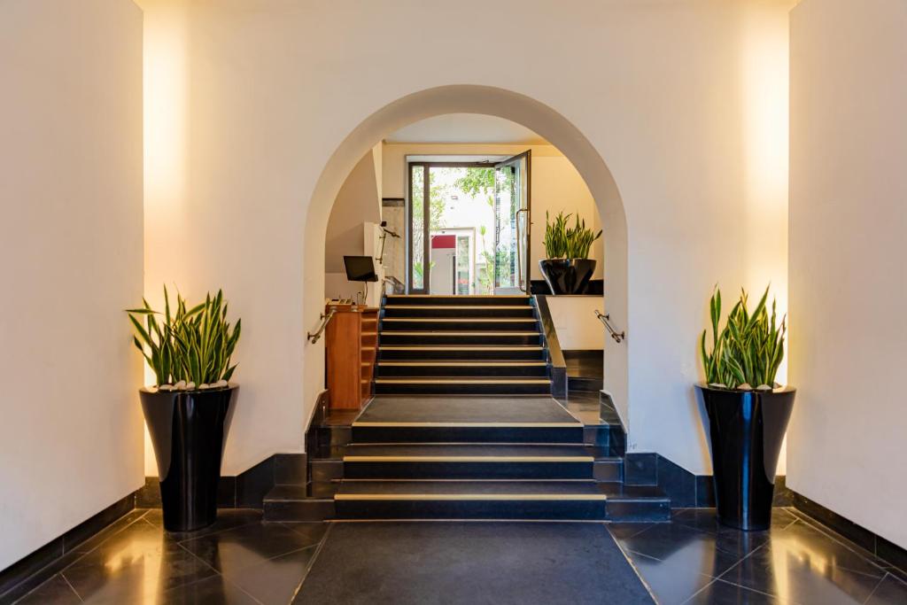 un corridoio con scale con piante in vaso di May Flower Luxury a Napoli