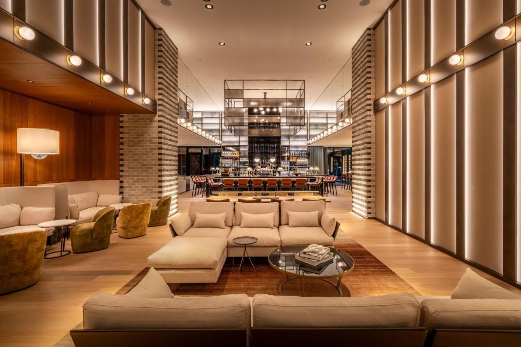 un soggiorno con divani e tavolo di Munich Marriott Hotel City West a Monaco