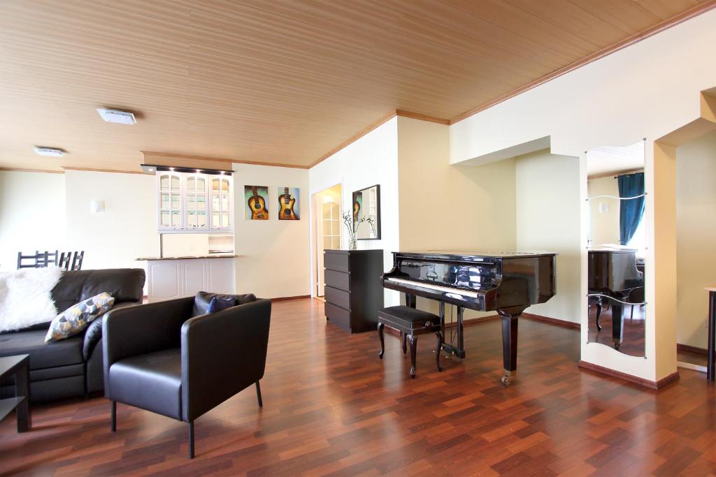 a living room with a piano and a couch at Peter the Great Apartments on Nevsky in Saint Petersburg