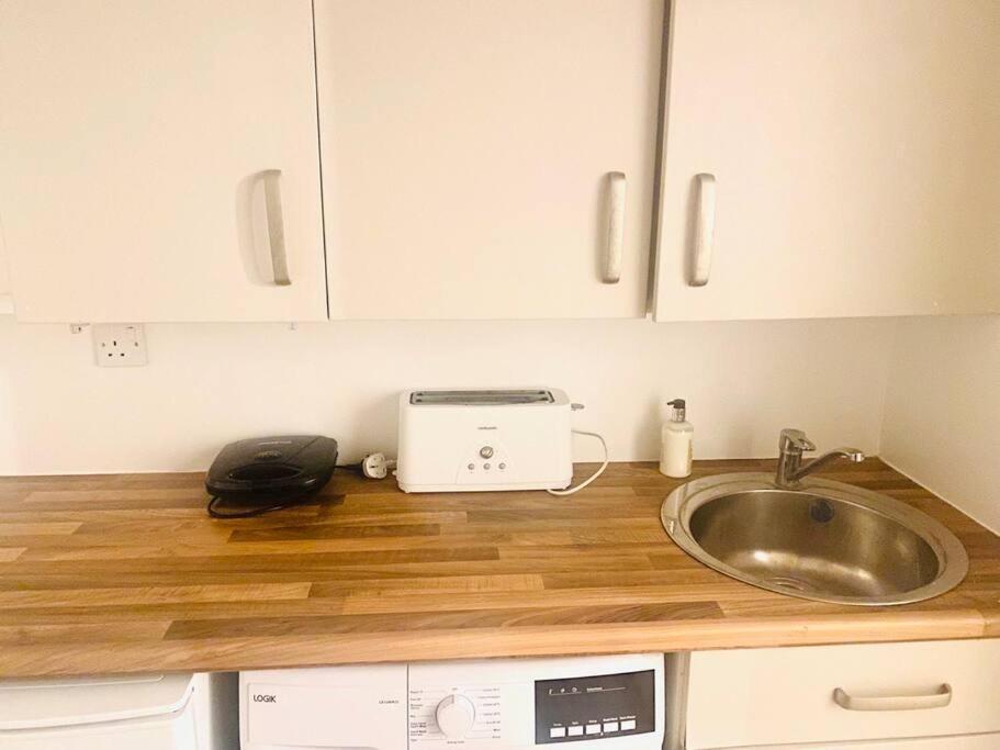 a kitchen counter with a sink and a toaster at Large self-contained cozy studio in London