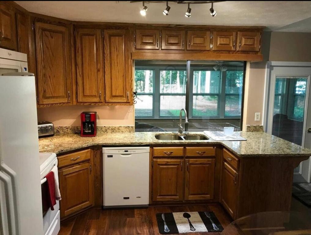 eine Küche mit Holzschränken und einem weißen Kühlschrank in der Unterkunft Carl Nespoli in Fayetteville