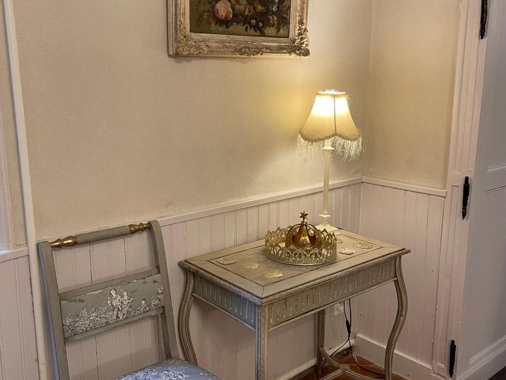 a table with a lamp and a chair in a room at Gîte Bazouges-sur-le-Loir, 6 pièces, 10 personnes - FR-1-410-377 in Bazouges-sur-le-Loir