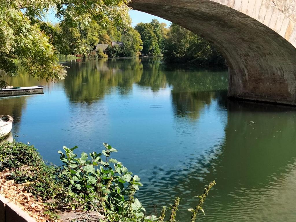 a bridge over a river with trees and water at Gîte Bazouges-sur-le-Loir, 6 pièces, 10 personnes - FR-1-410-377 in Bazouges-sur-le-Loir