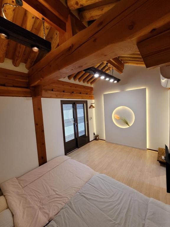 1 dormitorio con 1 cama en una habitación con techos de madera en Gyeongju Hwarangroo en Gyeongju