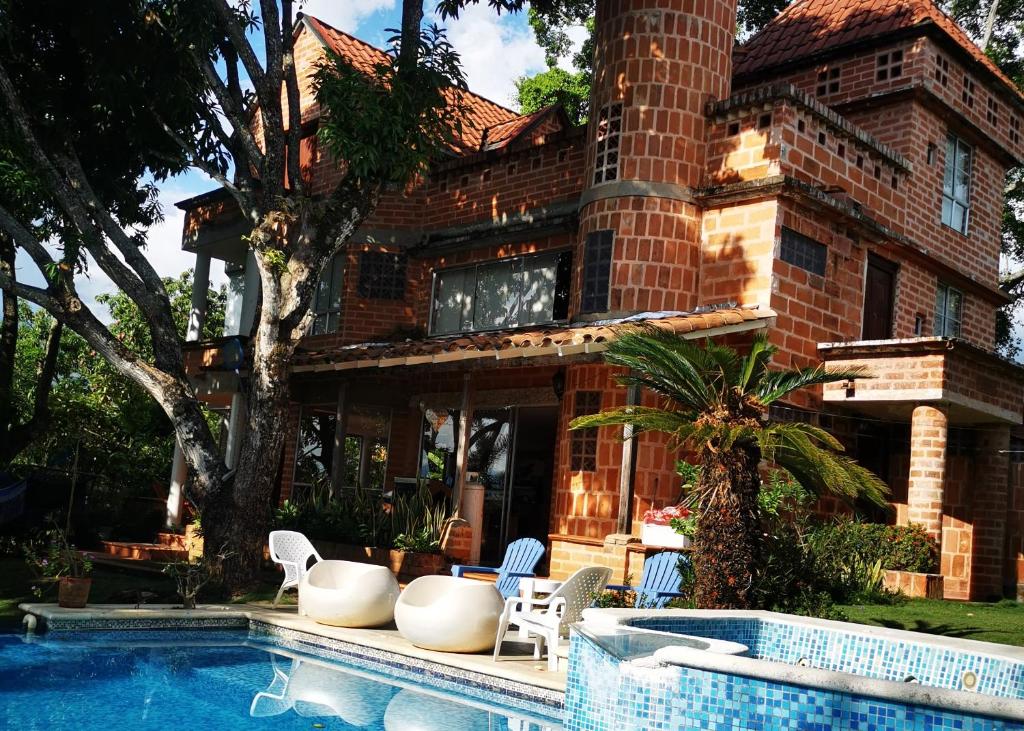 una casa con piscina frente a ella en Finca con forma de castillo y piscina en Sopetrán, en Sopetrán